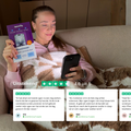 Vrouw met BlueShield blauw licht screen protector in hand, gebruikend een smartphone op de bank.